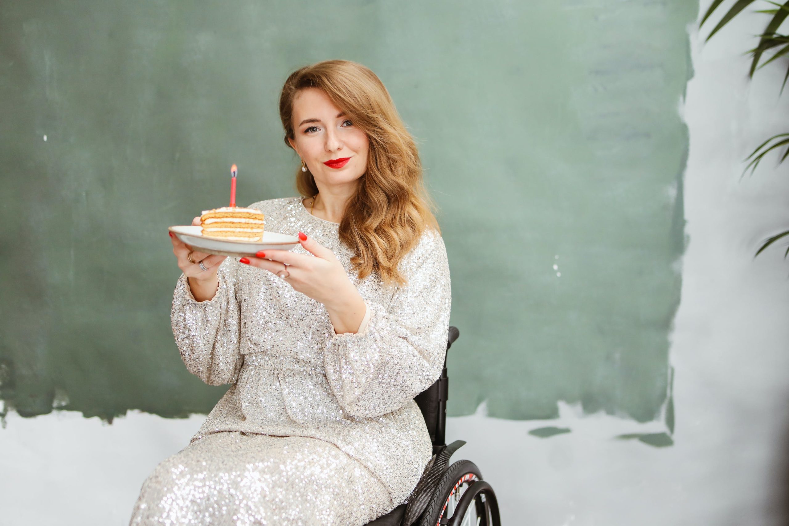 Woman in a wheelchair holding a birthday cake